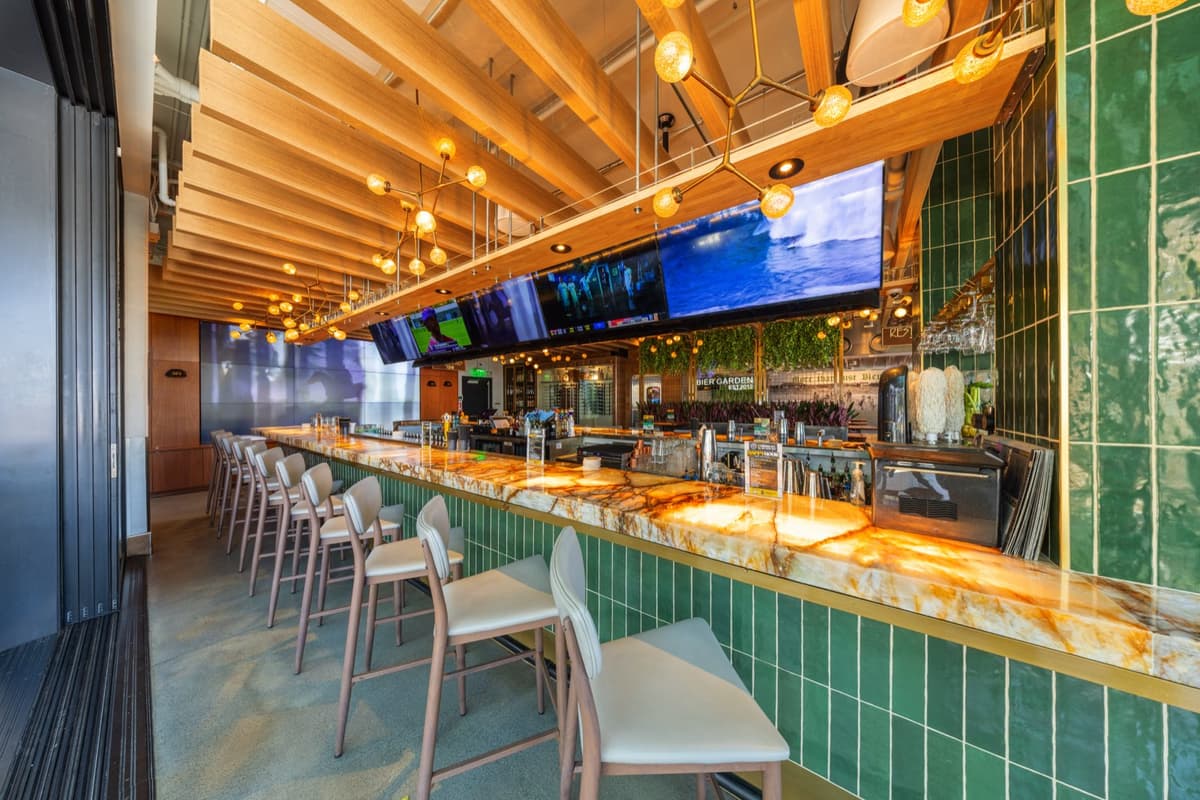 The bar rail with a glowing onyx counter and game-day screens